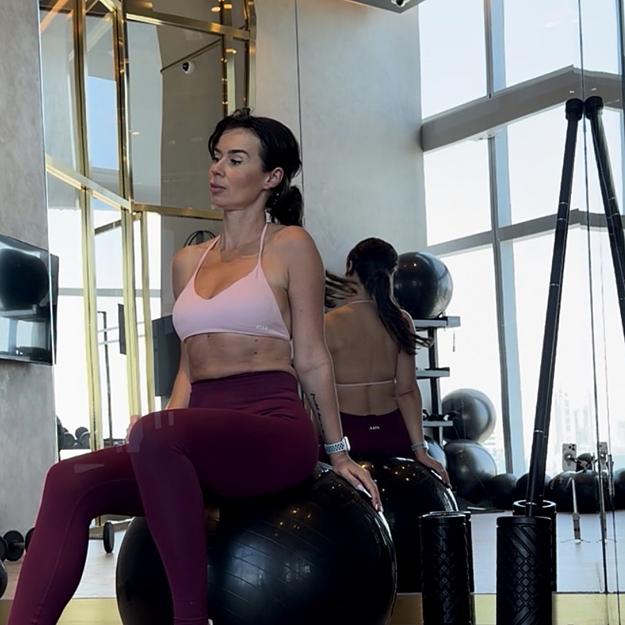Julita seated on a stability ball in the studio
